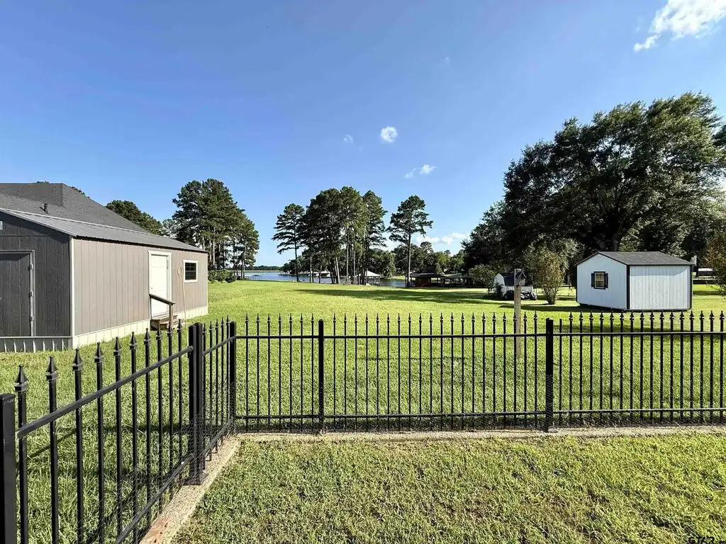 Oversized garage and shop building with a separate storage shed and a fenced yard running down to Lake Palestine at 644 An County Road 3009 in Frankston TX