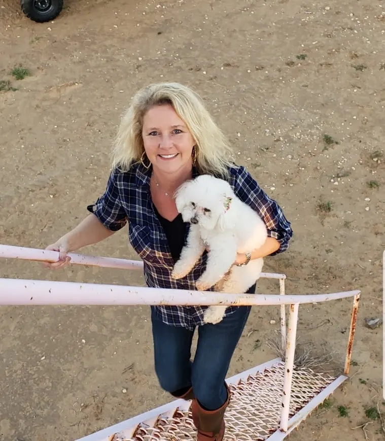 Charlene Hall, East TX Realtor®, holding her dog Mollie on a deer blind at Triple T Ranch in Encinal, Texas