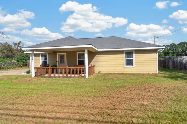 Front of the 3-bedroom home with its covered wood-railed porch at 1054 Caroline Ln in Shadybrook, a gated Lake Palestine community in Bullard, TX.