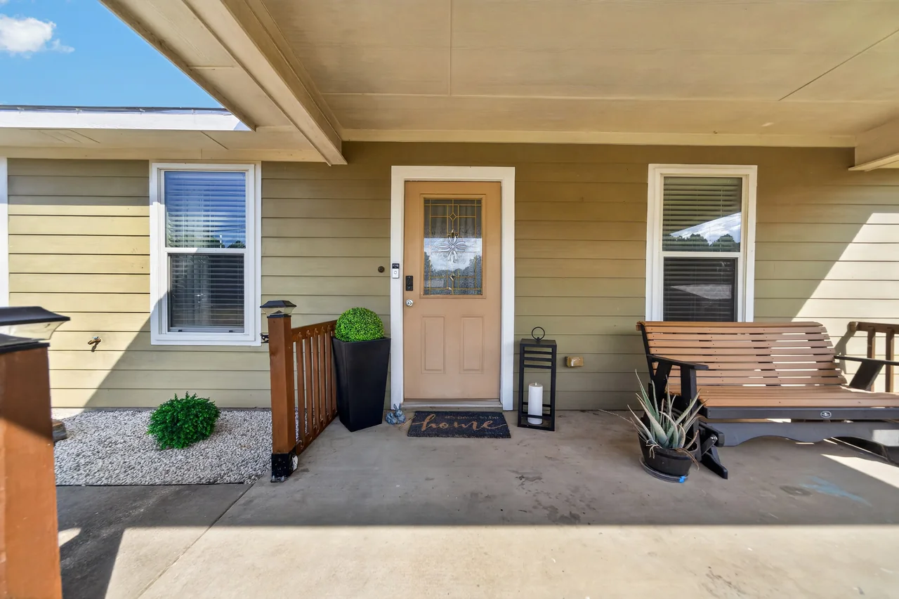 Covered front porch with wood railing at 1054 Caroline Ln in Shadybrook, a gated Lake Palestine community in Bullard, TX.