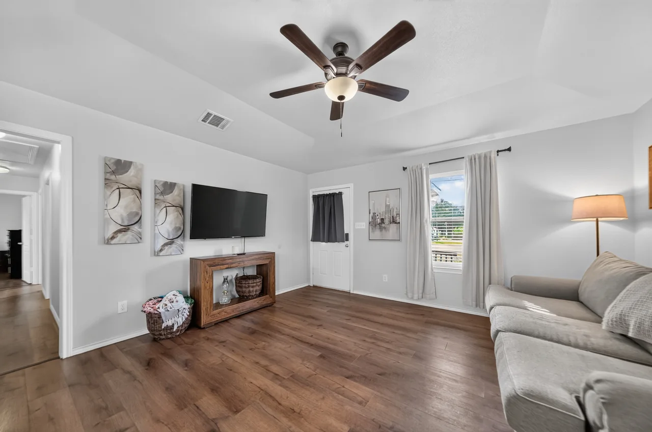 Living room with ceiling fan and tray ceiling at 1054 Caroline Ln in Shadybrook, a gated Lake Palestine community in Bullard, TX.