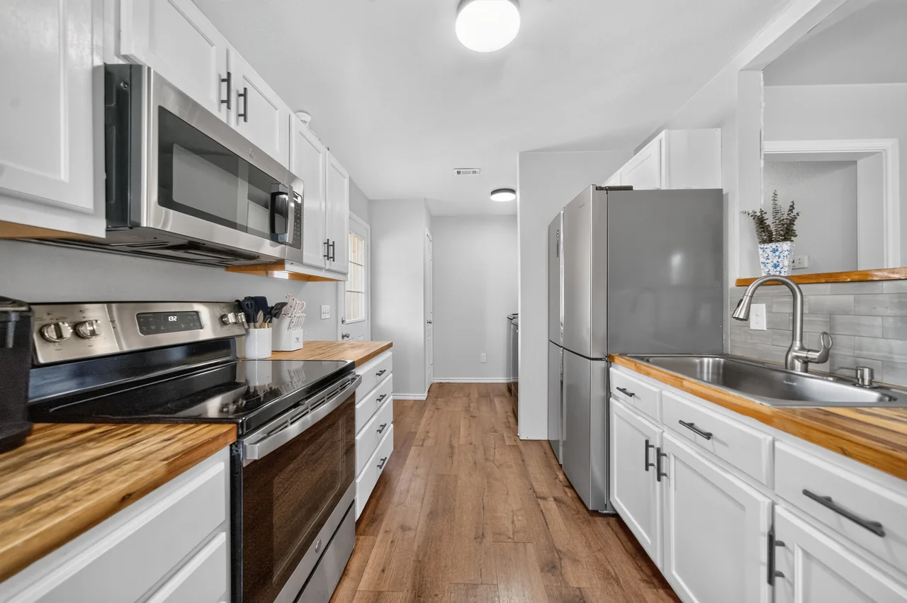 Galley kitchen with a stainless range, microwave and refrigerator at 1054 Caroline Ln in Shadybrook, a gated Lake Palestine community in Bullard, TX.