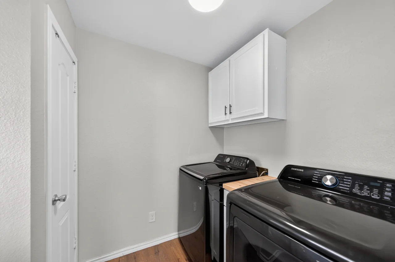 Laundry room with upper cabinets at 1054 Caroline Ln in Shadybrook, a gated Lake Palestine community in Bullard, TX.