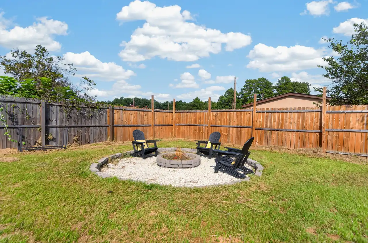 Backyard fire pit area inside the wood privacy fence at 1054 Caroline Ln in Shadybrook, a gated Lake Palestine community in Bullard, TX.