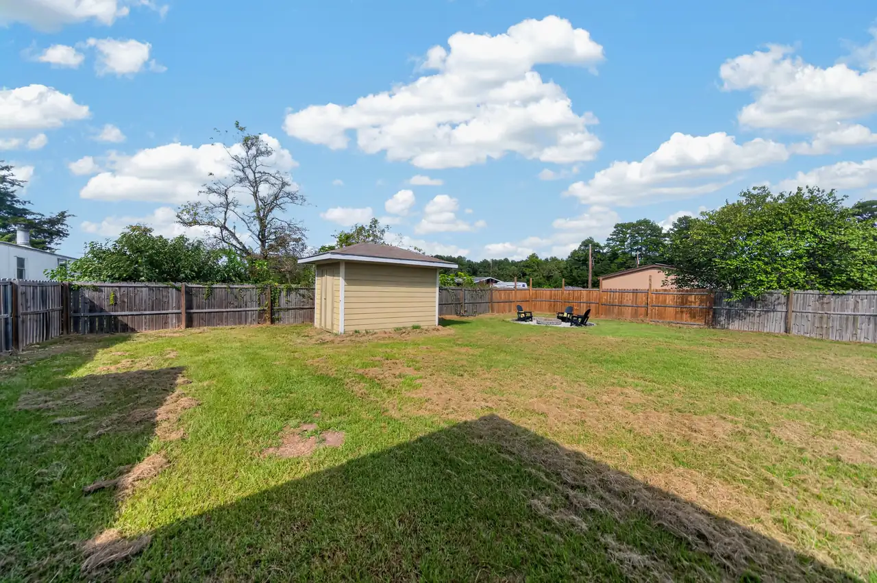 Matching storage building in the fenced backyard at 1054 Caroline Ln in Shadybrook, a gated Lake Palestine community in Bullard, TX.