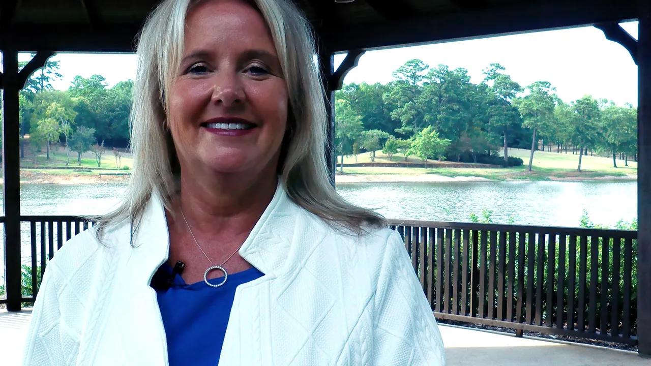Charlene Hall, GRI REALTOR&reg;, speaking to camera under a lakeside gazebo on Lake Palestine, East Texas