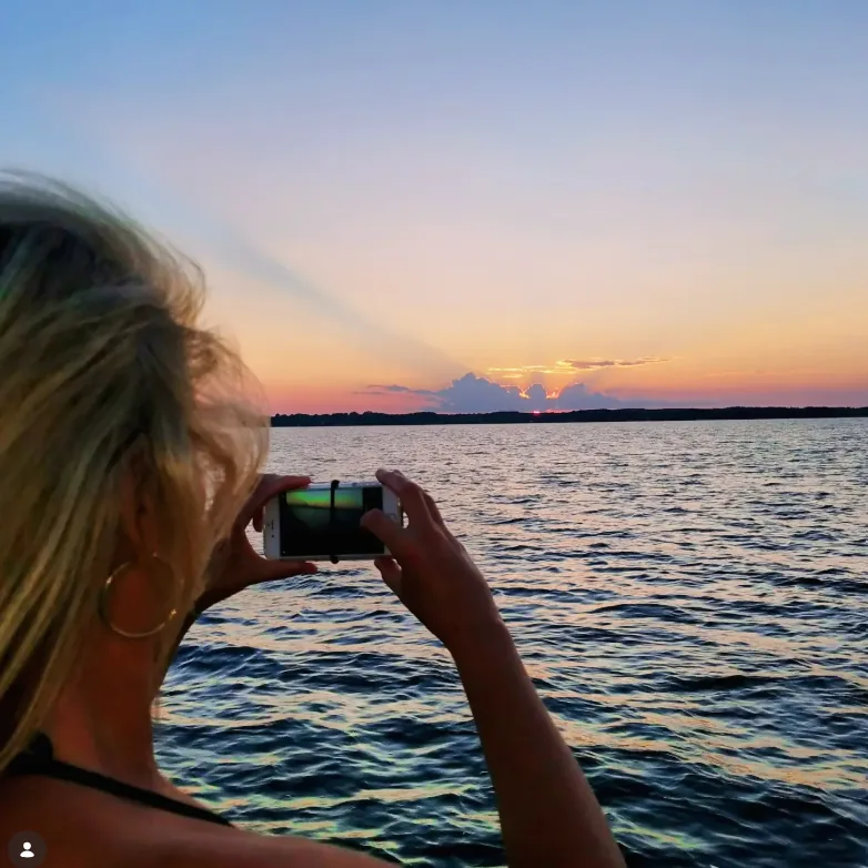 Charlene Hall, East TX Realtor, photographing a sunset over open water on Lake Palestine.